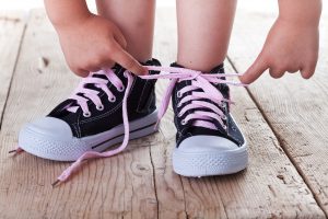 bigstock-Child-Successfully-Ties-Shoes-34396691