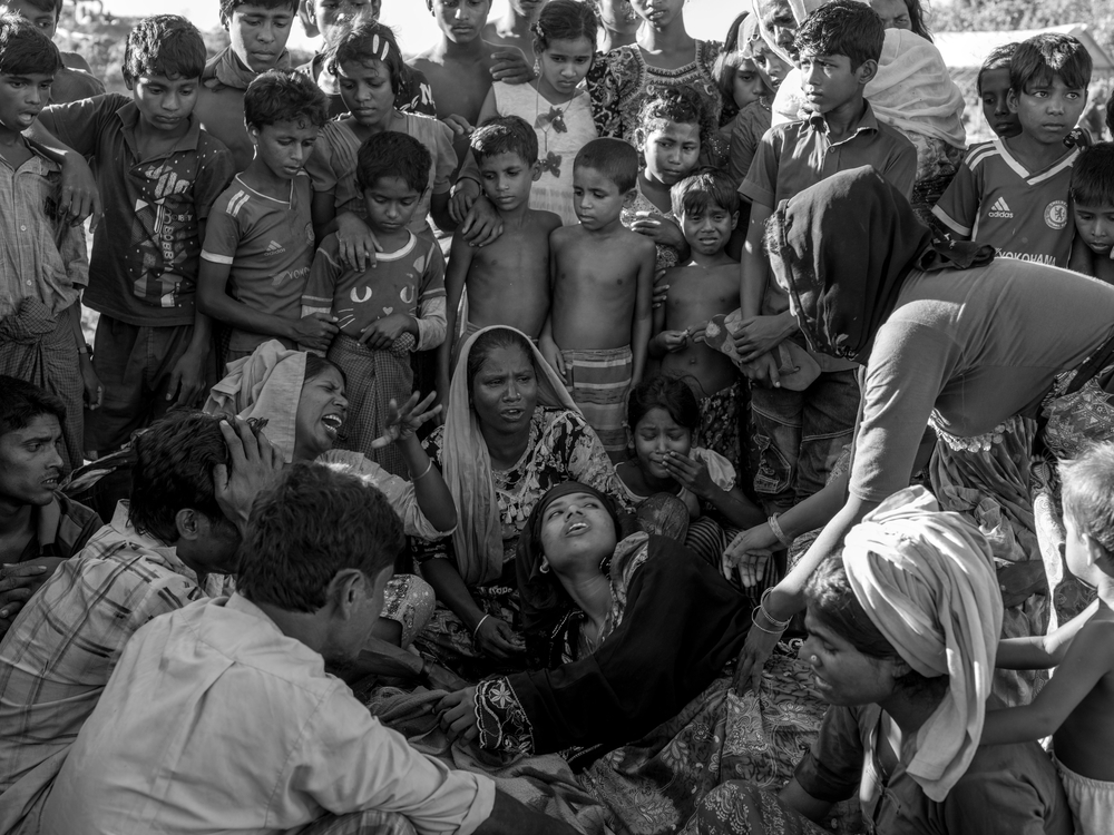 Μπανγκλαντές: Οι συγγενείς της Αμίνα Κατούν, μιας 60χρονης πρόσφυγα Ροχίνγκια, που πέθανε από επιπλοκές που συνδέονται με τον υποσιτισμό, πενθούν δίπλα από τη σορό της στον καταυλισμό Μπαλουκχαλί. (Οκτώβριος 2017).